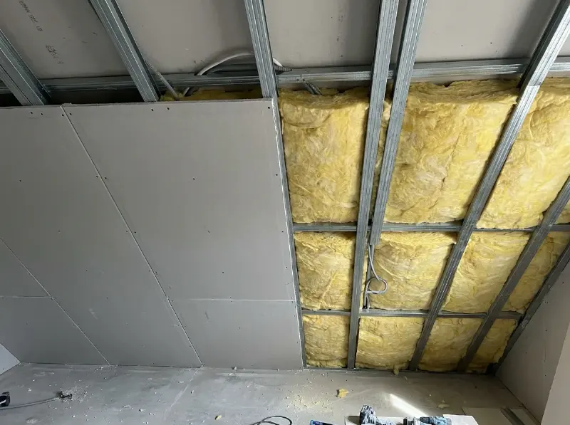 Gyprocplafond half geplaatst op metalen profielen met isolatie ertussen